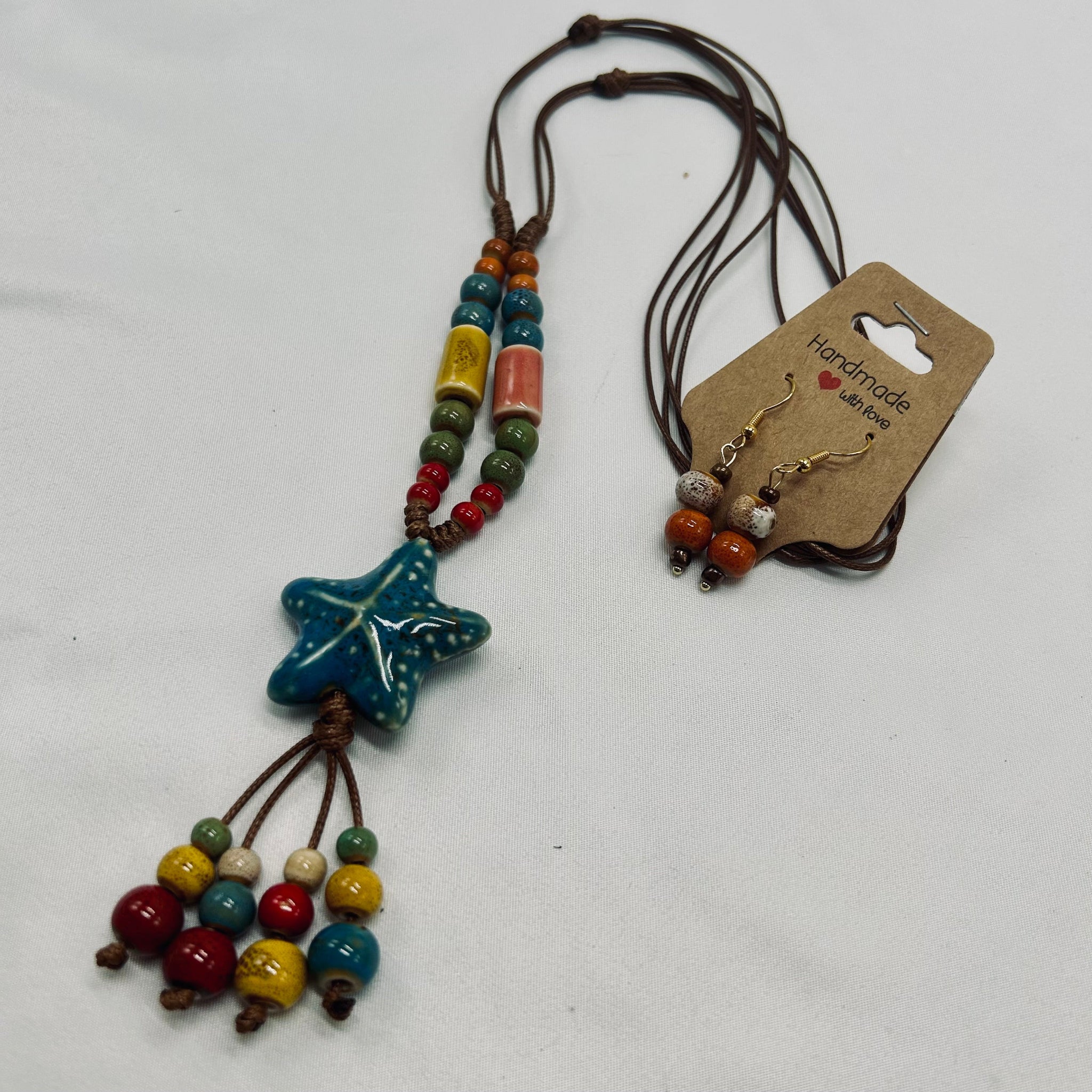 Beaded necklace with star-shaped pendant and matching earrings on a white background
