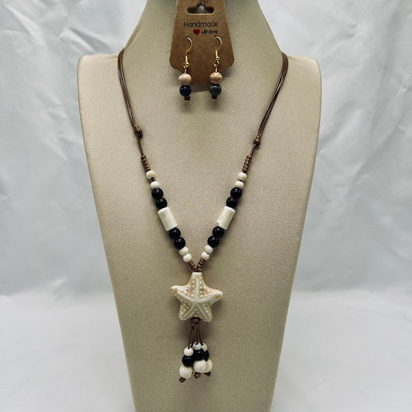 Necklace with star pendant and matching earrings on a mannequin bust with 'Handmade' label.
