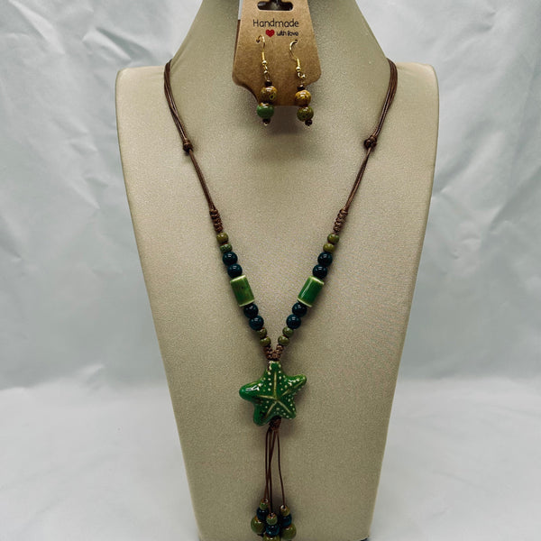 Necklace with starfish pendant and matching earrings on a mannequin bust.