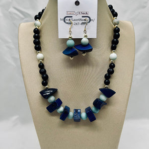 Necklace and earrings set on a mannequin bust with a visible brand tag.