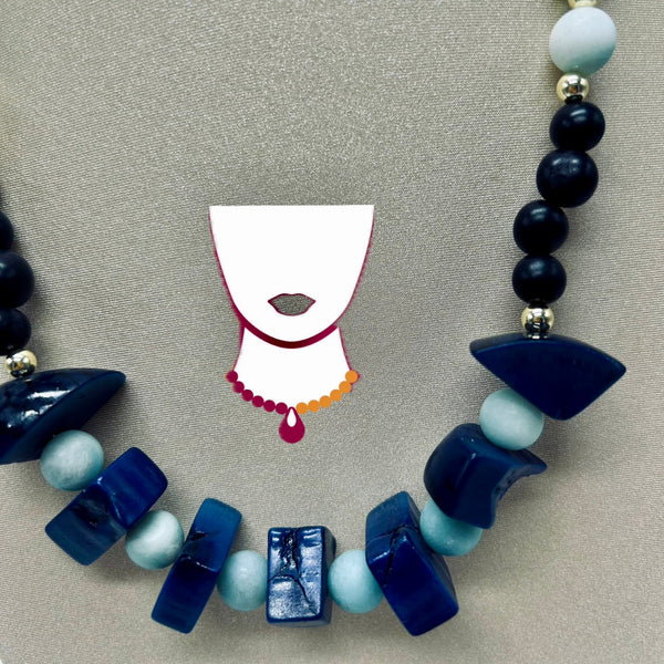 Necklace with blue and white beads and a small mask illustration on a gray background