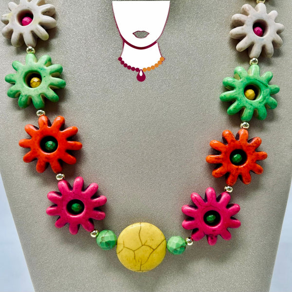 Colorful necklace with floral and round beads on a gray background