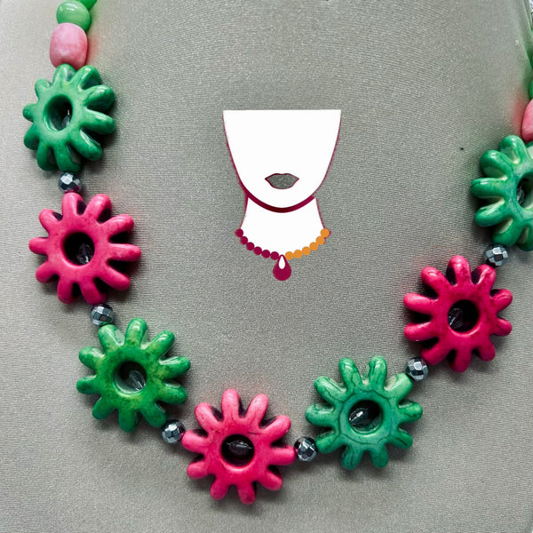 Necklace with pink and green gear-shaped beads on a gray background