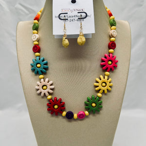 Colorful necklace and earrings set on a mannequin bust with a visible brand tag.