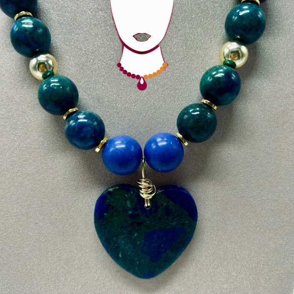 Necklace with blue and green beads on a gray background