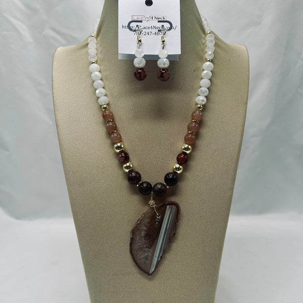 Necklace and earrings set on a mannequin bust with a visible brand tag.