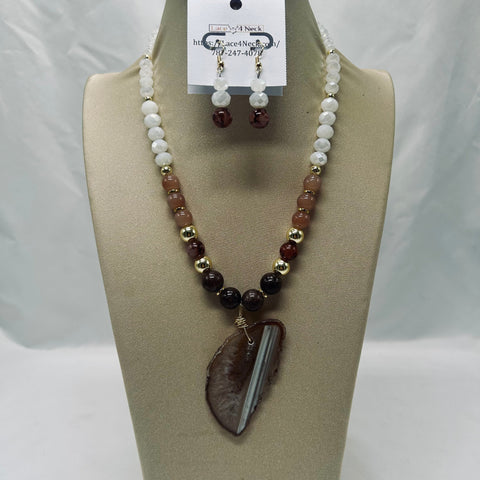 Necklace and earrings set on a mannequin bust with a visible brand tag.