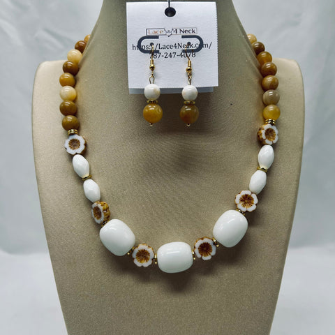 Necklace and earrings set on a mannequin bust with a visible brand tag.