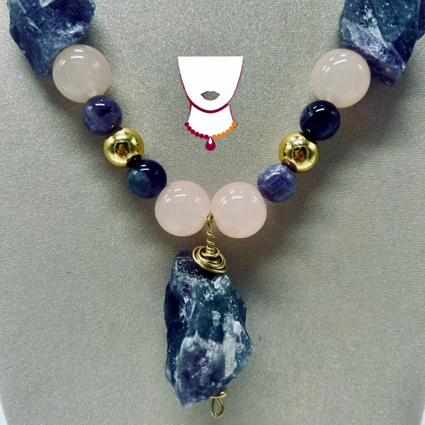 Necklace with blue and pink beads on a gray background