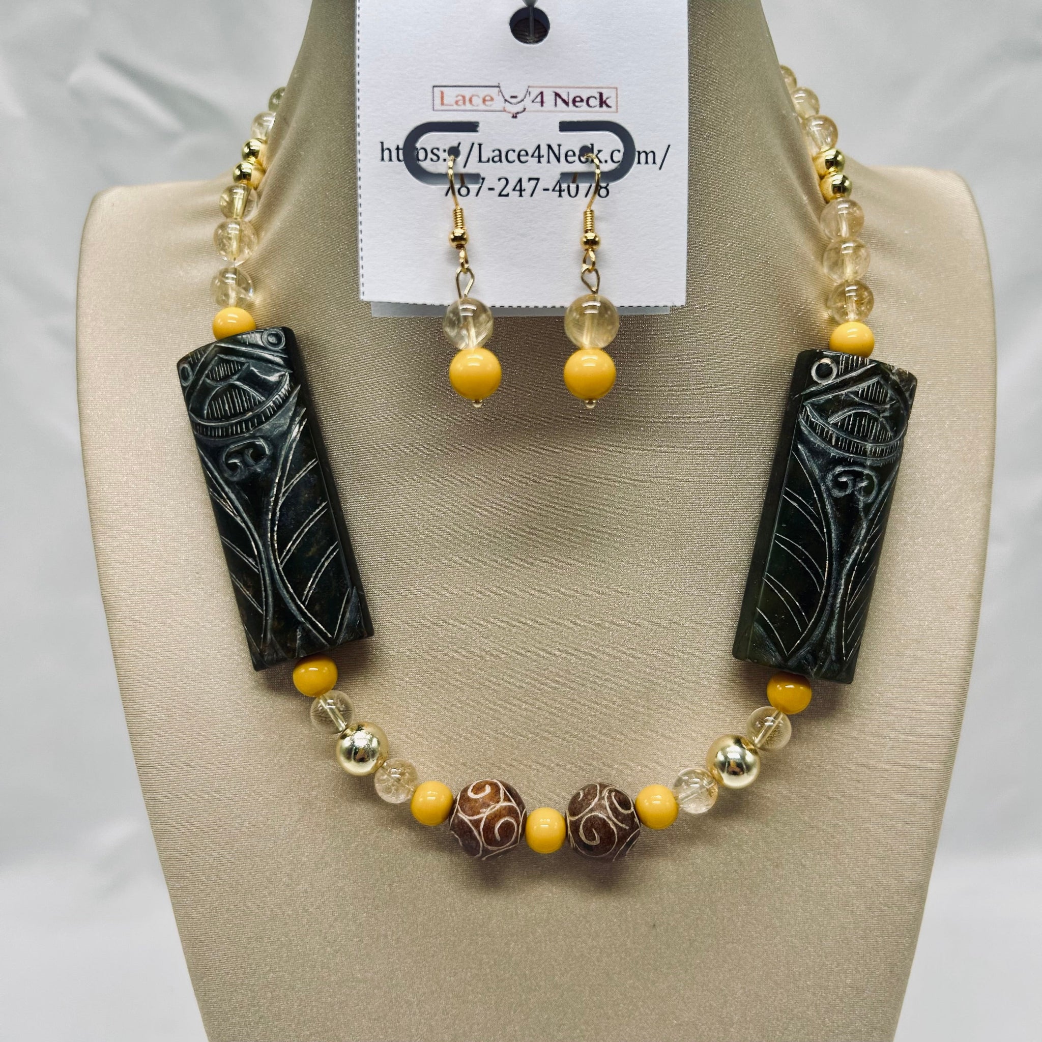 Necklace and earrings set with black and yellow beads on a mannequin bust.