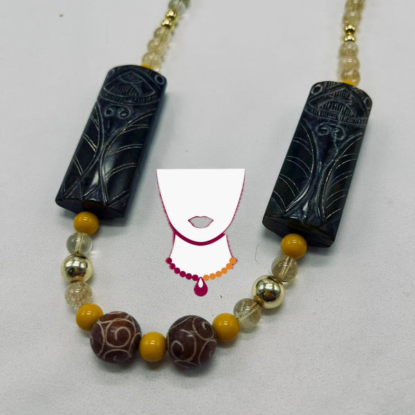 Necklace with black and gold beads on a white background
