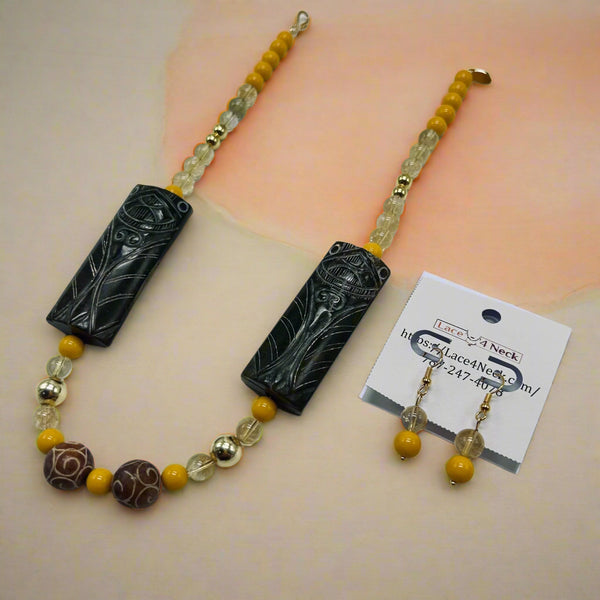 Beaded necklace with black decorative elements on a white background