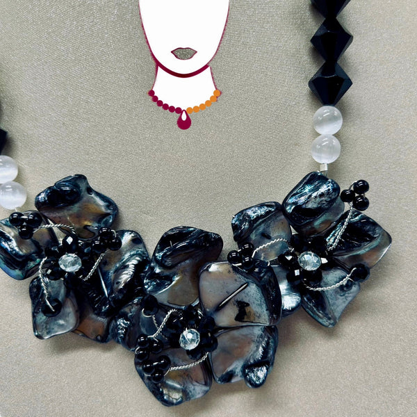 Necklace with black and gray floral beads on a beige background