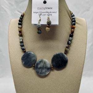 Necklace and earrings set on a mannequin bust with a visible brand label.
