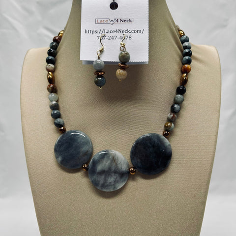 Necklace and earrings set on a mannequin bust with a visible brand label.