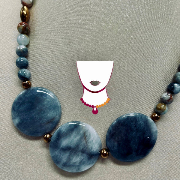Necklace with blue marbled beads and gold accents on a gray background