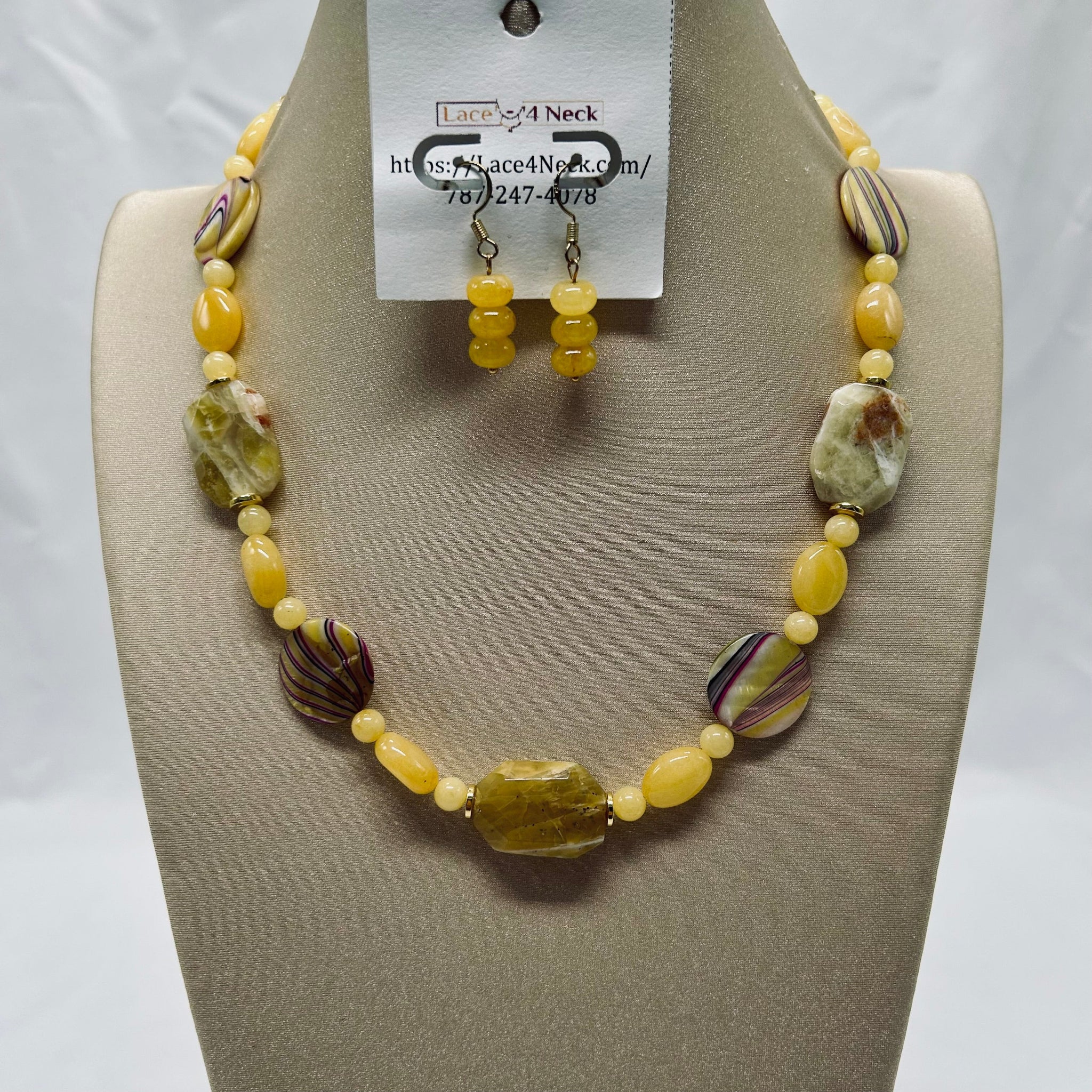 Necklace and earrings set on a mannequin with a visible brand tag.