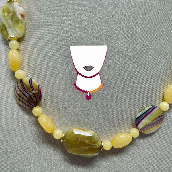 Necklace with yellow and patterned beads on a gray background