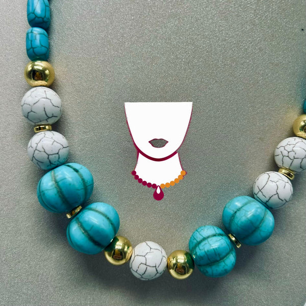 A beaded necklace with large turquoise-blue marbled beads, white marble-like beads with black veining, and shiny gold spacer beads, arranged on a gray textured background. A stylized white neck graphic with red lips and a small necklace illustration sits in the center.