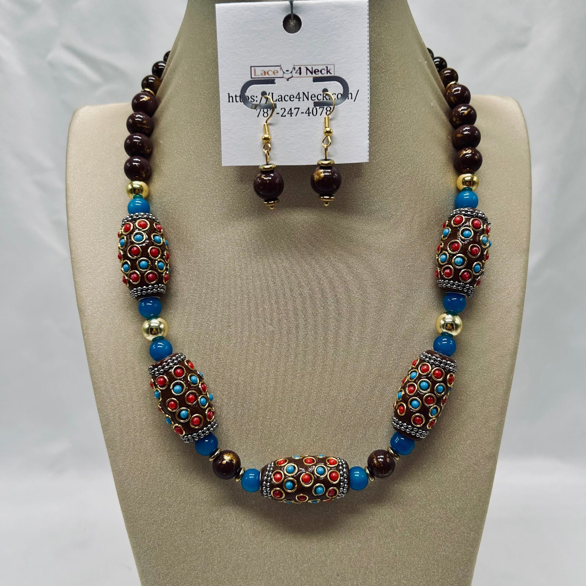 Beaded necklace and earrings set on a mannequin bust with a visible brand tag.