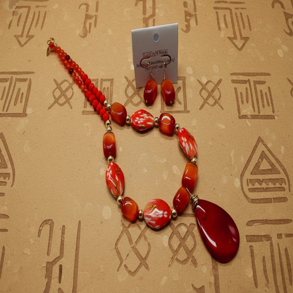 Red beaded necklace with a large red pendant on a white background
