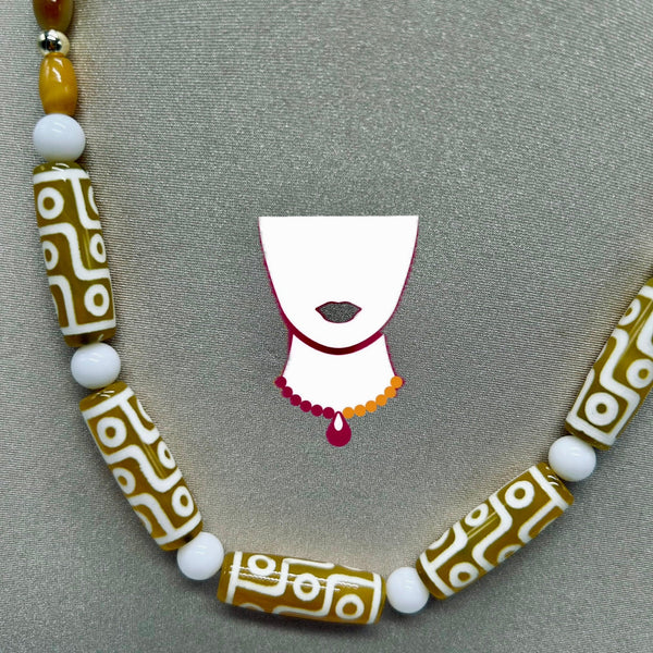 Necklace with patterned beads and a small decorative piece on a gray background