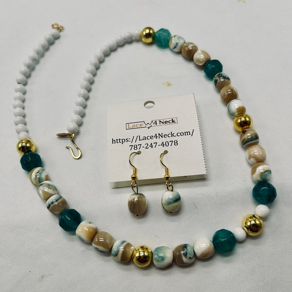 A beaded jewelry set on a light gray background, featuring a necklace, matching drop earrings, and a small display card. The beads are marbled in teal, cream, white, and brown, with shiny gold-toned metal findings and hooks.
