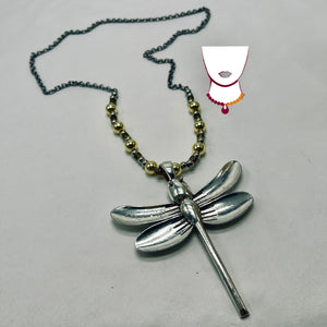 Silver dragonfly pendant on a chain with a gray background