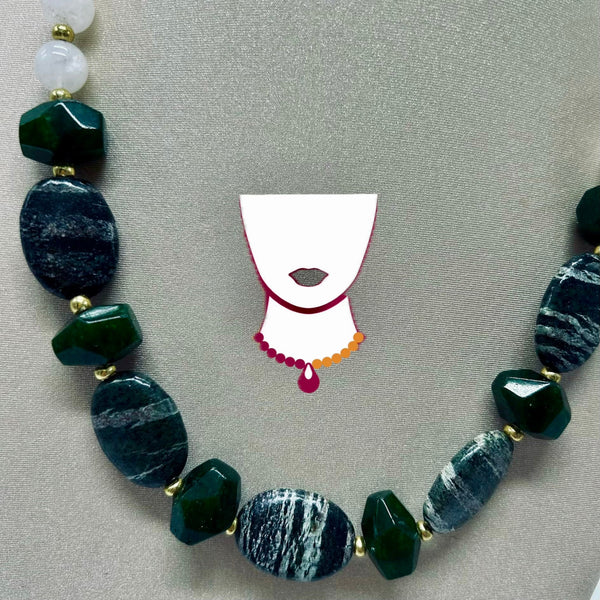 Necklace with green and blue beads on a gray background with a stylized face illustration.