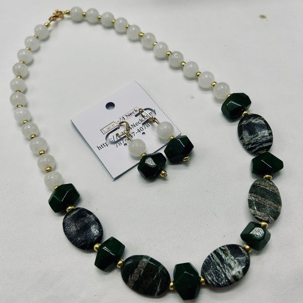 Necklace with green and white beads on a white background.