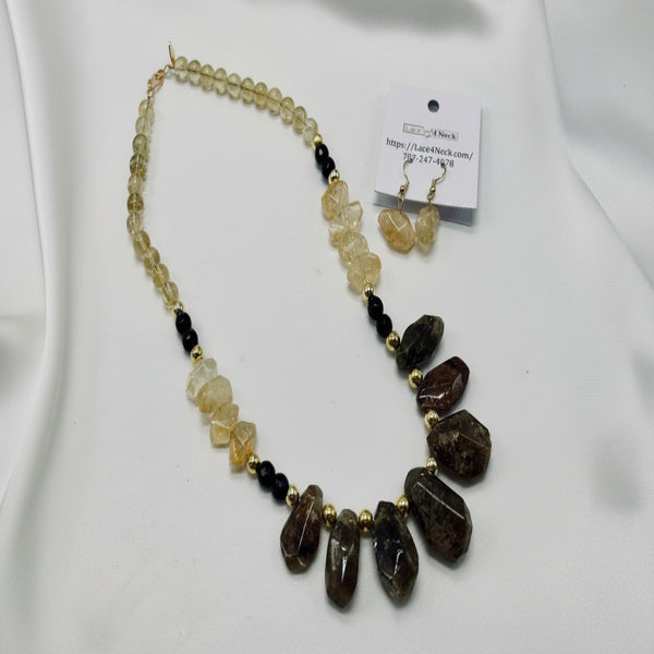 Necklace with green, yellow, and black stones on a white background.
