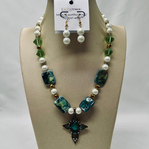 Necklace and earrings set on a mannequin bust with a visible brand tag.