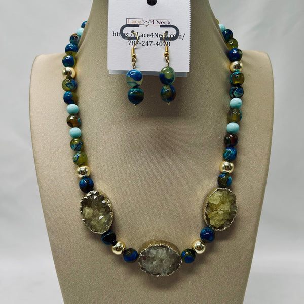 Necklace and earrings set on a mannequin bust with a visible brand tag.