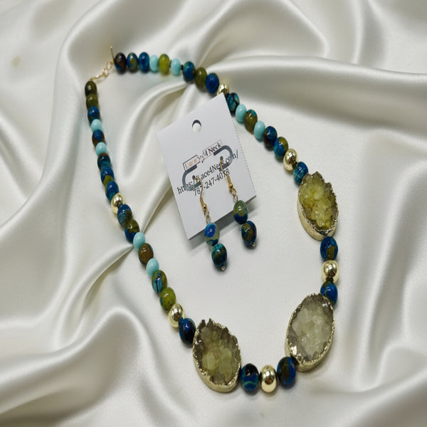 Necklace with blue and green beads and large stone-like beads on a white background