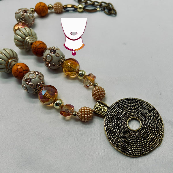 Necklace with beads and a large decorative pendant on a light gray background