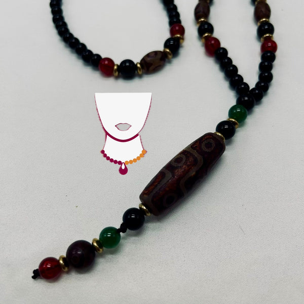 Beaded necklace with dark and red beads on a light gray background