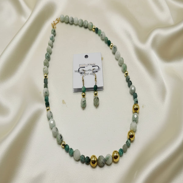 Necklace and earrings set with green and gold beads on a white background