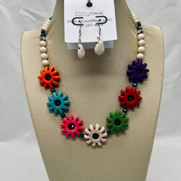 Colorful necklace with flower-shaped beads on a mannequin bust, with a tag indicating brand and contact information.