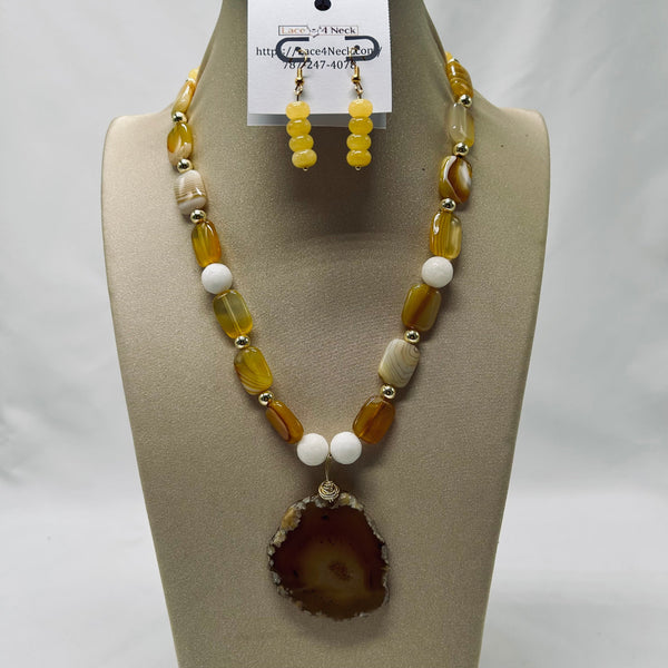 Necklace and earrings set on a mannequin bust with a visible brand tag.