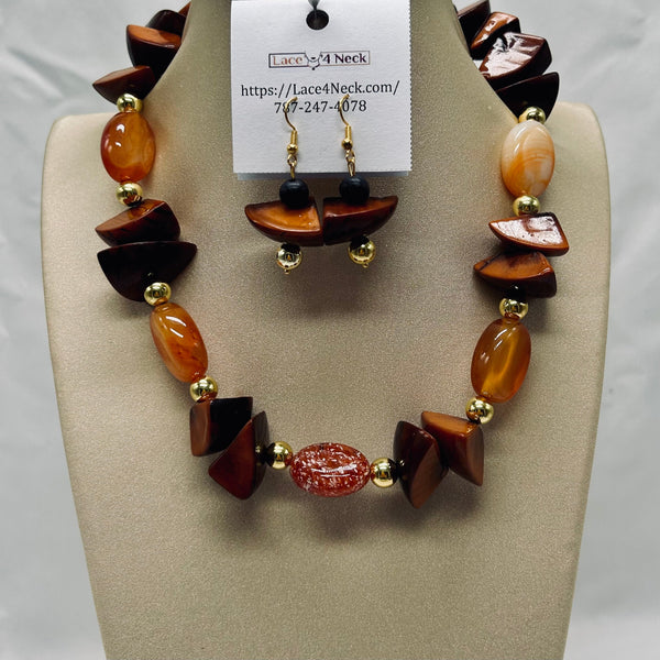 Necklace and earrings set on a display stand with a visible brand tag.