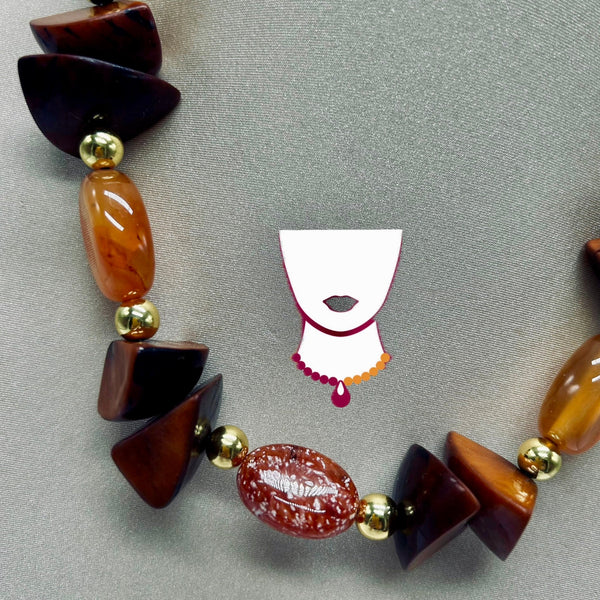 Beaded necklace with brown and gold beads on a gray background