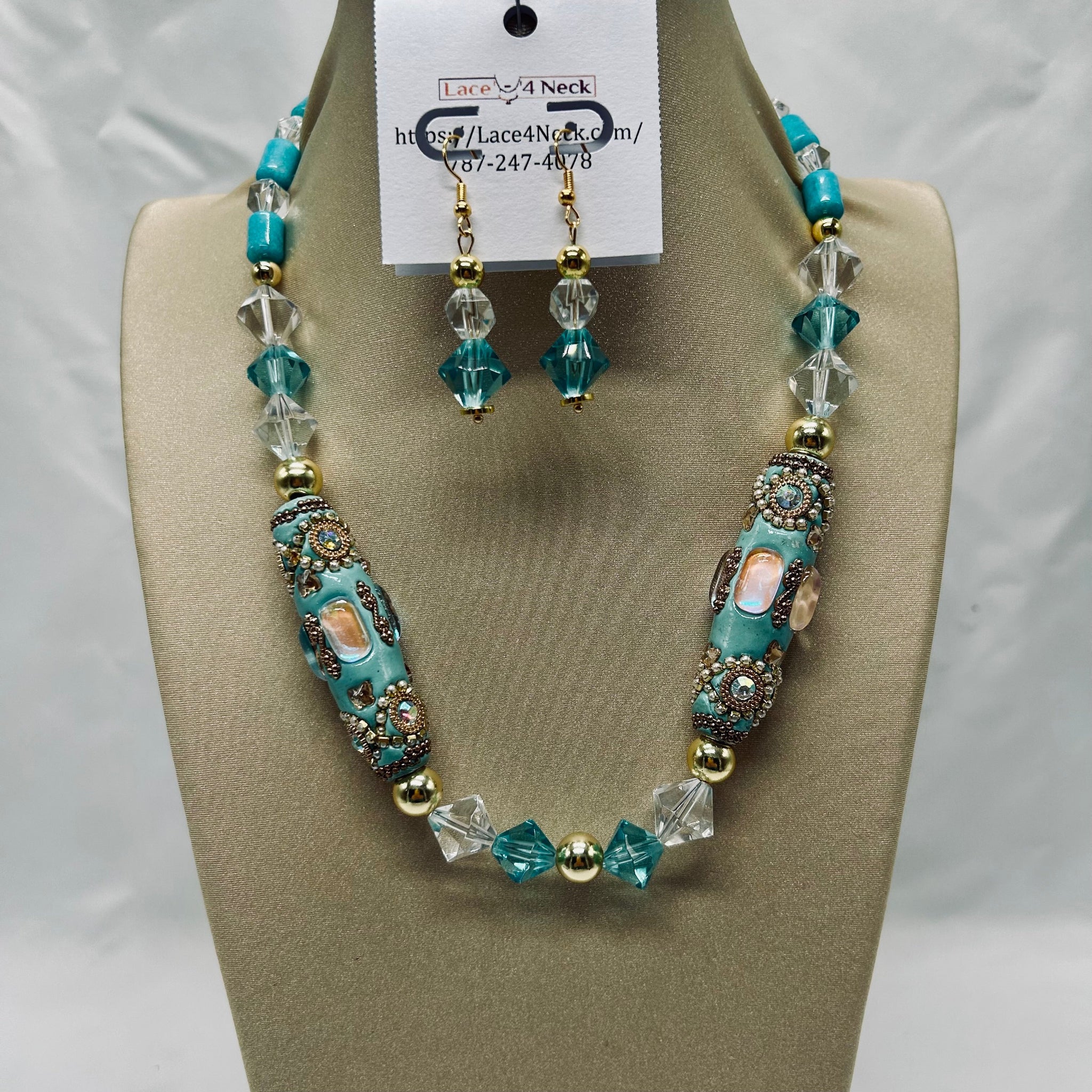 Turquoise and clear beaded necklace and earrings on a display stand with a visible brand tag.
